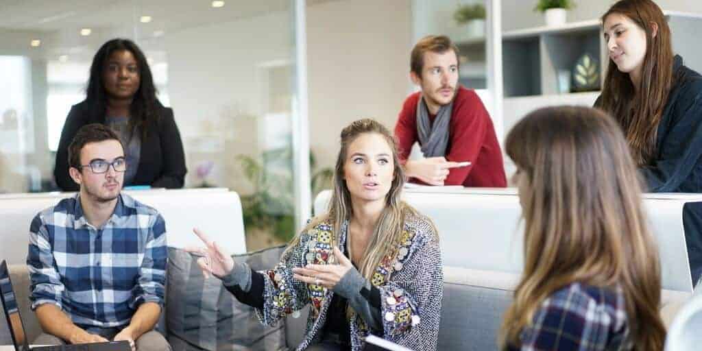 Group standing around networking in a meeting room.