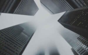 |What to look for in a good web designer with binoculars overlayed over view upwards between big city skyscrapers.|Download the free question checklist to hire a good web designer.