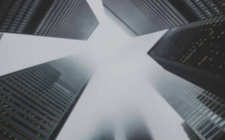 |What to look for in a good web designer with binoculars overlayed over view upwards between big city skyscrapers.|Download the free question checklist to hire a good web designer.