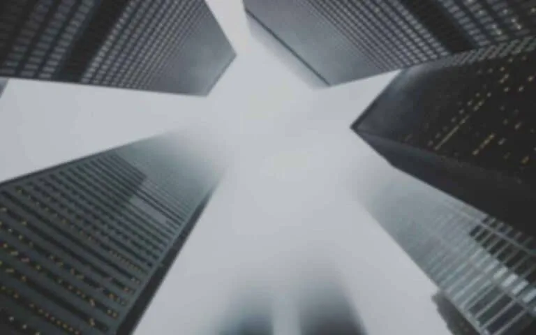 |What to look for in a good web designer with binoculars overlayed over view upwards between big city skyscrapers.|Download the free question checklist to hire a good web designer.